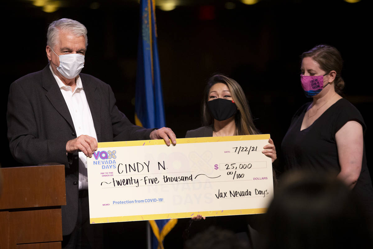 Gov. Steve Sisolak and Immunize Nevada hand over a check to Cindy N. for $25,000 during the ann ...