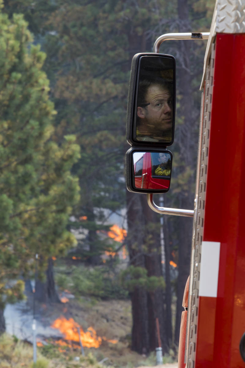 A So-Cal fireman is reflected in a side mirror around California State Route 88 near Alpine Vil ...