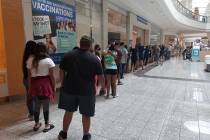 Several dozen people line up for the opening of a coronavirus vaccination clinic at the Galleri ...