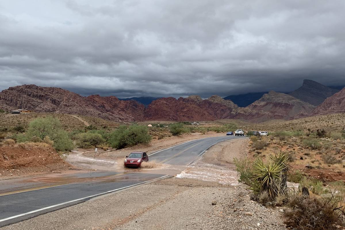 A car crosses flood water on Calico Basin Road in western Las Vega. (David Guzman/Las Vegas Rev ...