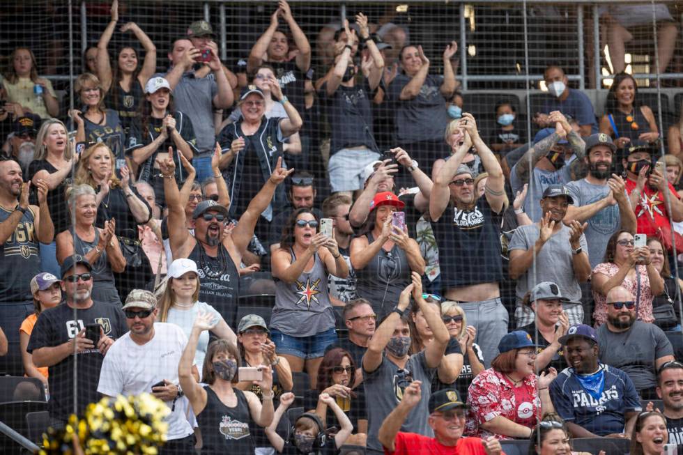 Fans cheers for the players during a charity softball game involving teammates from the Vegas G ...