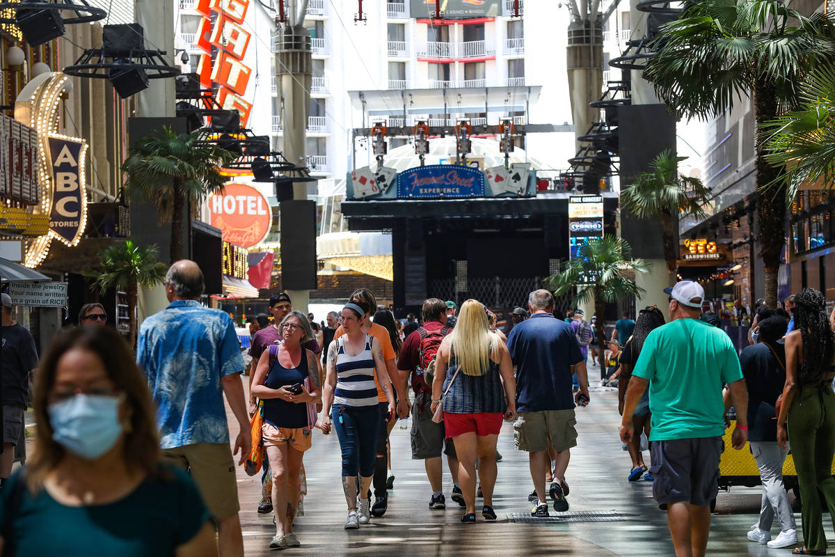Visitors walk under the Fremont Street Experience in Downtown Las Vegas Wednesday, July 28, 202 ...