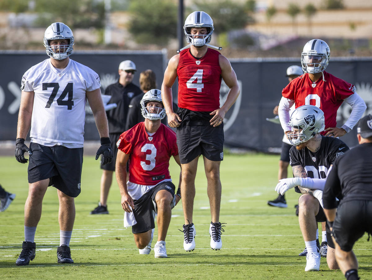 Raiders quarterback Derek Carr (4) jumps in the air while warming up with quarterback Nathan Pe ...