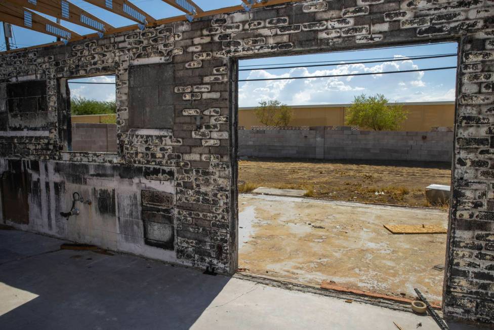 An exposed interior brick wall a burned-out house that is currently listed for sale along the 3 ...