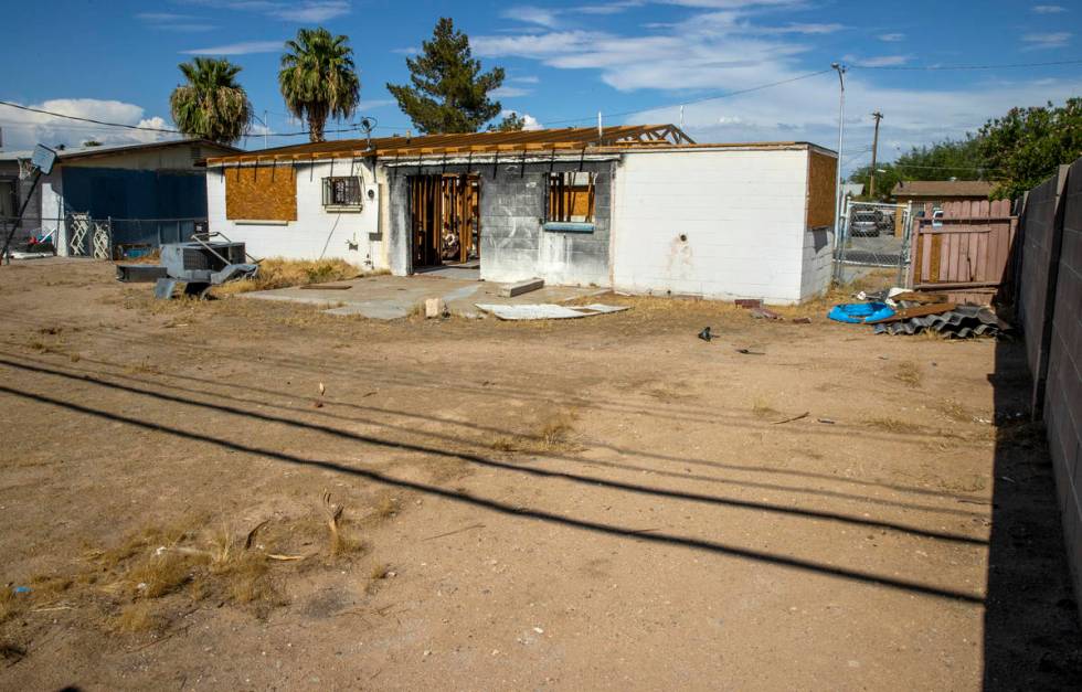 Boarded up windows on the exterior of a burned-out house that is currently listed for sale alon ...