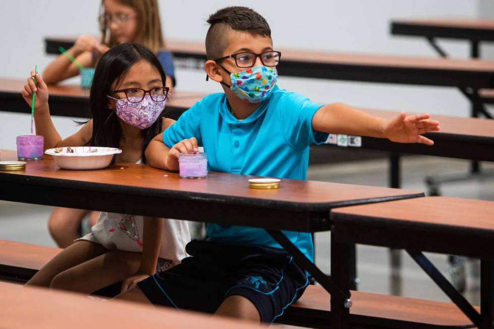 Ellura H., 8, and Giani B., 8, mix paints in the cafeteria as Giani reaches towards another cam ...