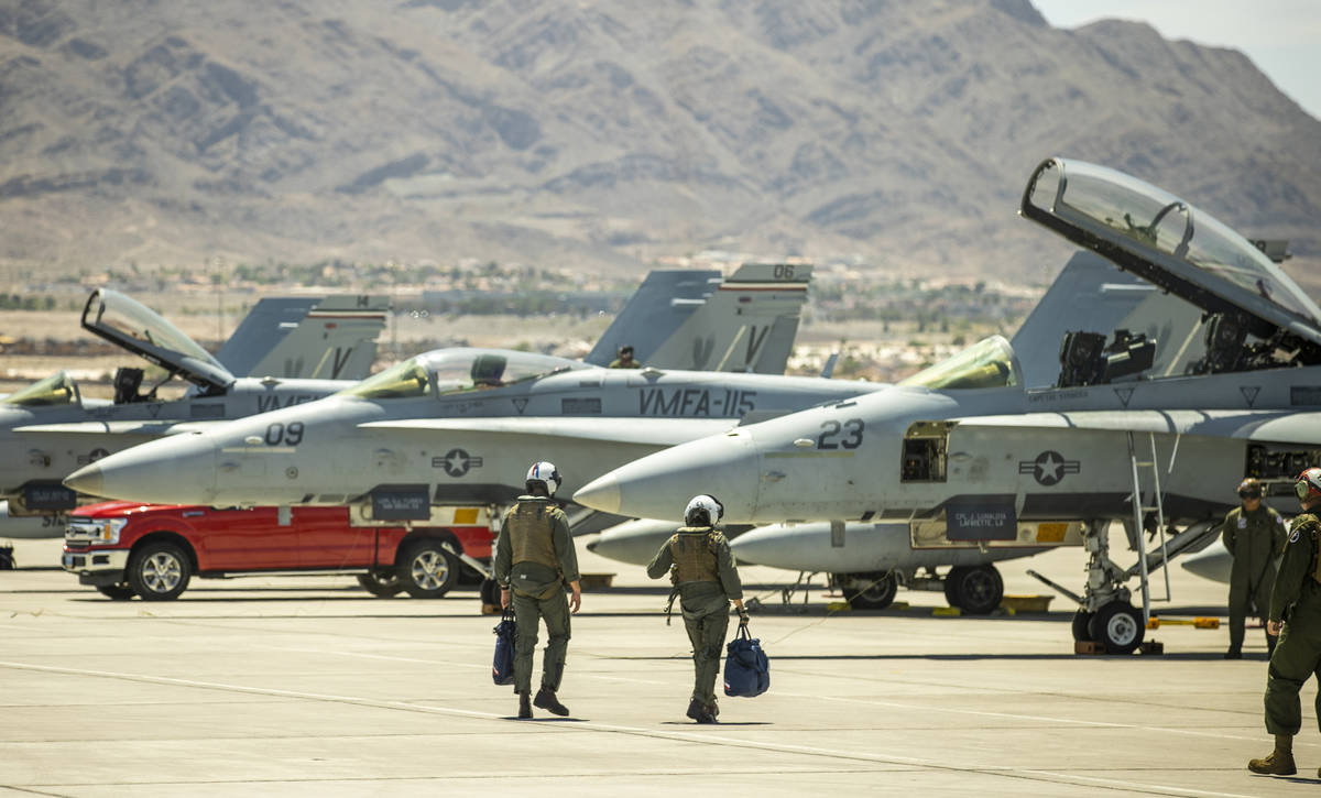 Pilots walk to their jets on the flight line as Nellis Air Force Base hosts a RED FLAG exercise ...