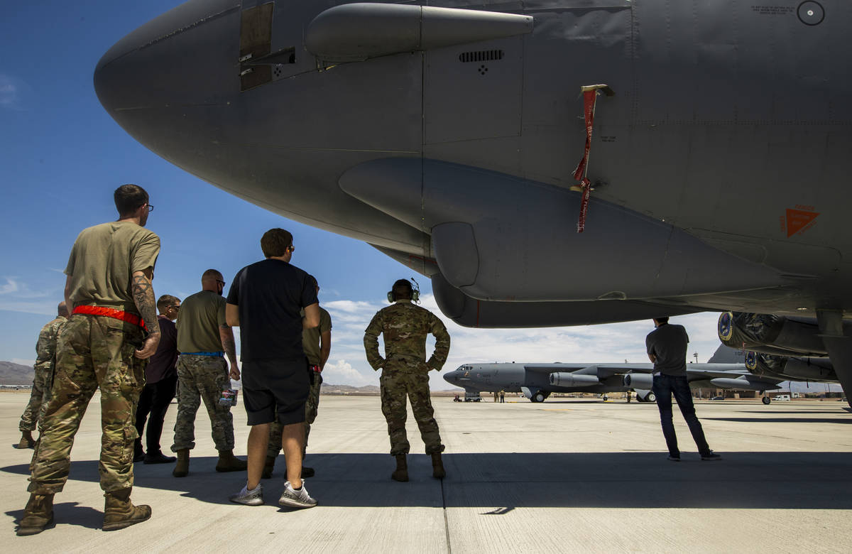 Crew members and others look on as B-52 Bomber rolls back into its spot on the flight line as N ...