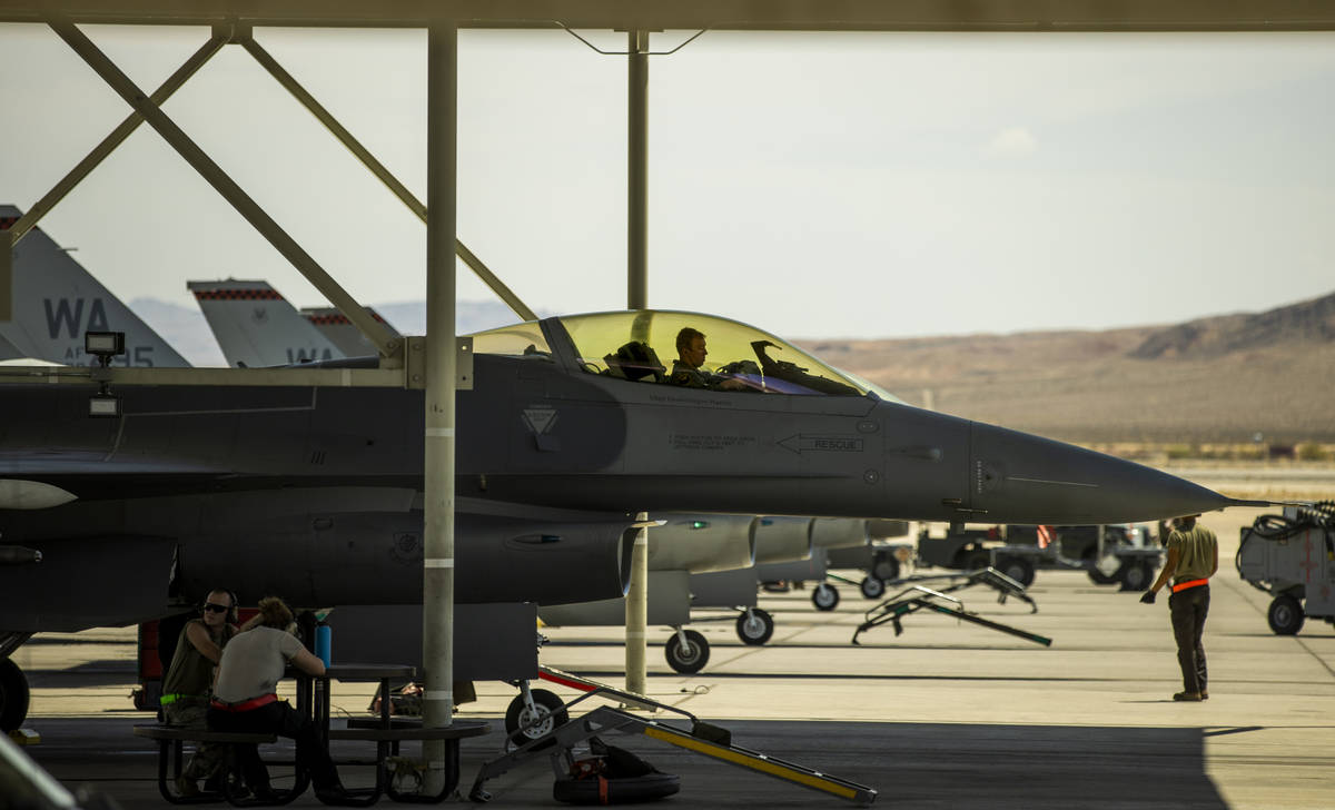 A pilot sits in the cockpit as another jet is ready for action as Nellis Air Force Base hosts a ...