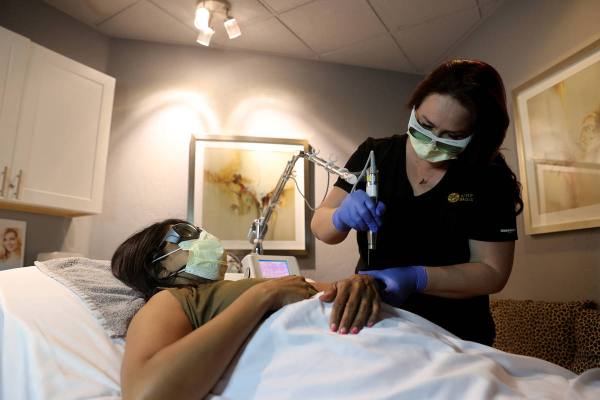 Laser technician Jennifer Knepper does hair removal on client Netrani Sharma at Simply Radiant ...