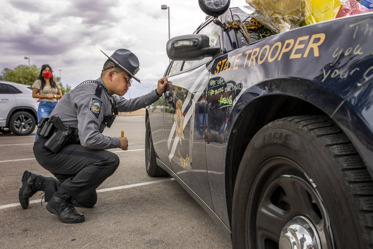 Nevada Highway Patrol trooper Noah Villa takes a quiet moment after signing car #203 driven by ...