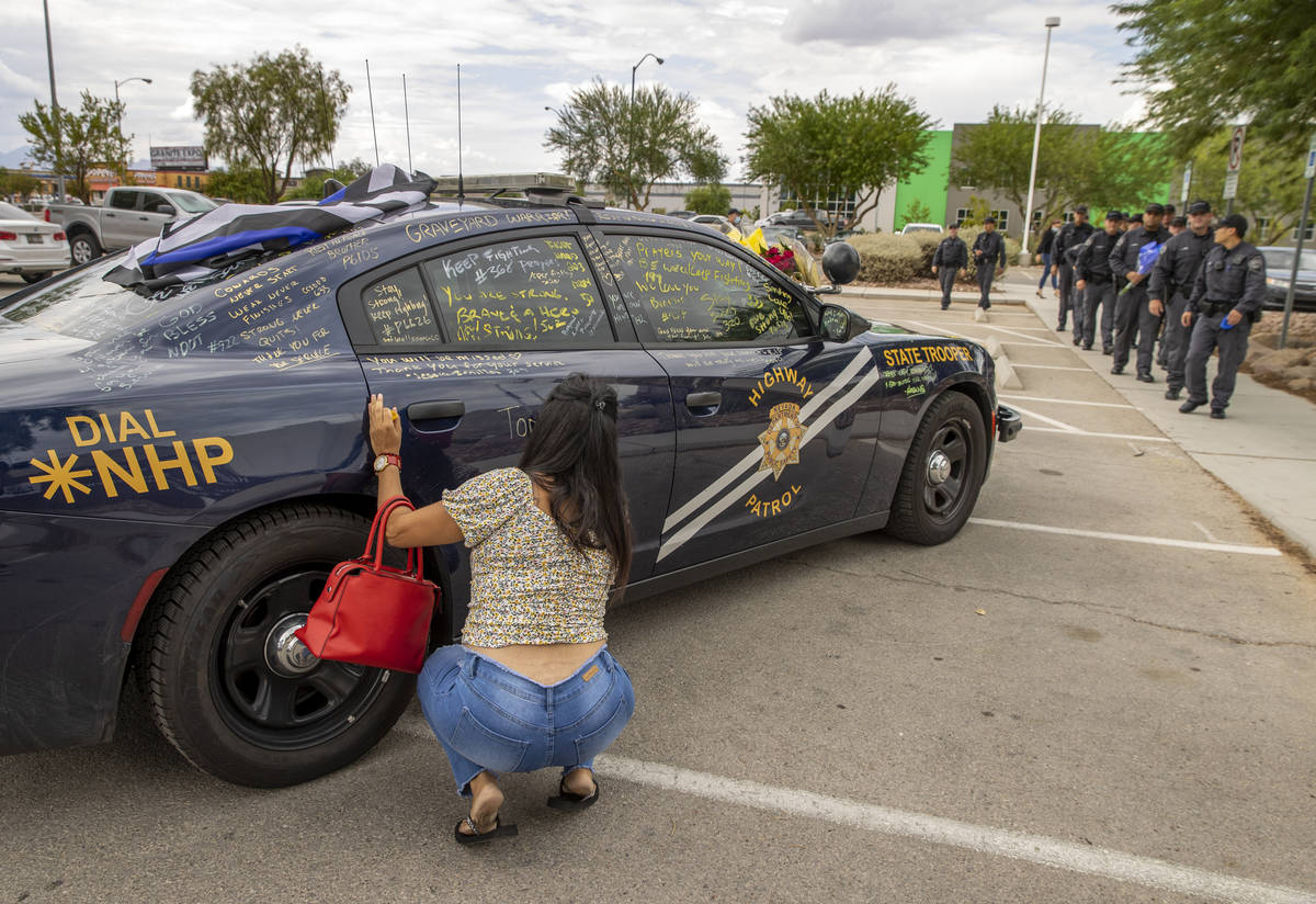 Well wishers are able to sign car #203 driven by Nevada Highway Patrol trooper Micah May parked ...