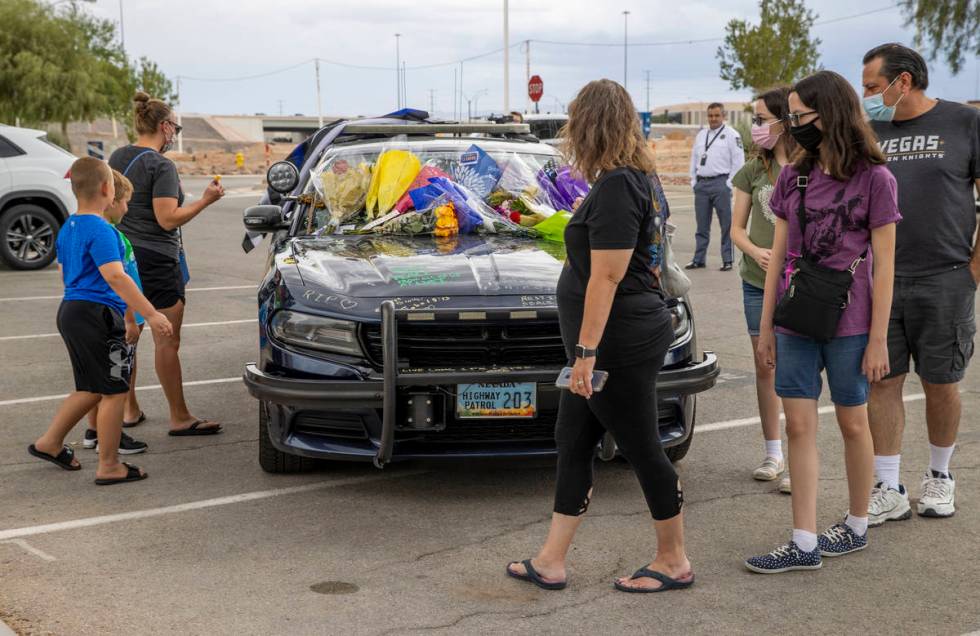 Well wishers arrive to view and sign car #203 driven by Nevada Highway Patrol trooper Micah May ...