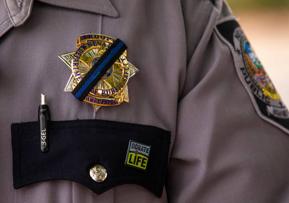 Nevada Highway Patrol trooper Noah Villa wears a black band on his badge in remembrance of fell ...