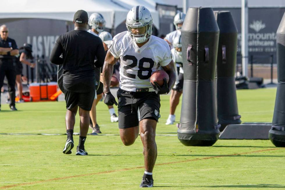 Raiders running back Josh Jacobs (28) runs through a drill during their NFL training camp pract ...