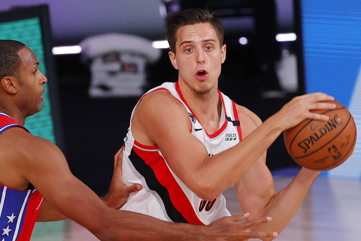 Portland Trail Blazers' Zach Collins, right, looks to pass against Philadelphia 76ers' Al Horfo ...