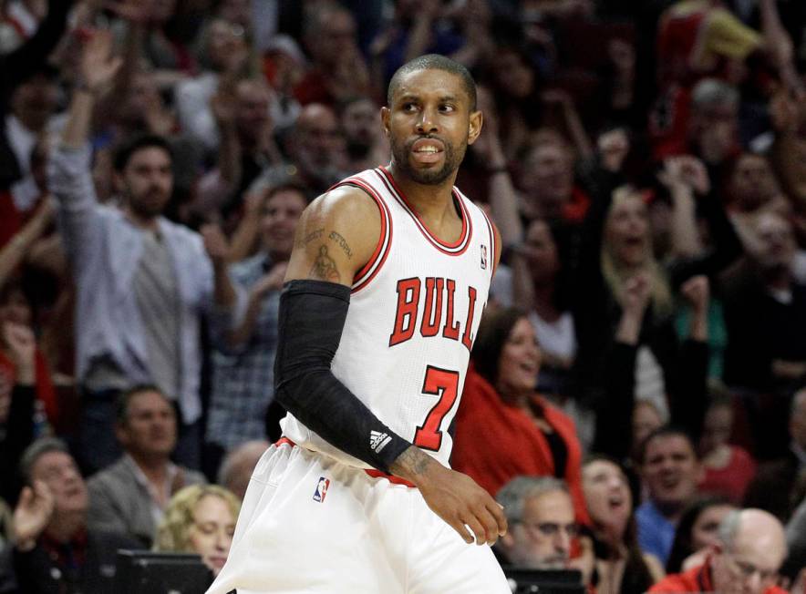 As fans, background, react, Chicago Bulls guard C.J. Watson (7) looks at the basket after scori ...