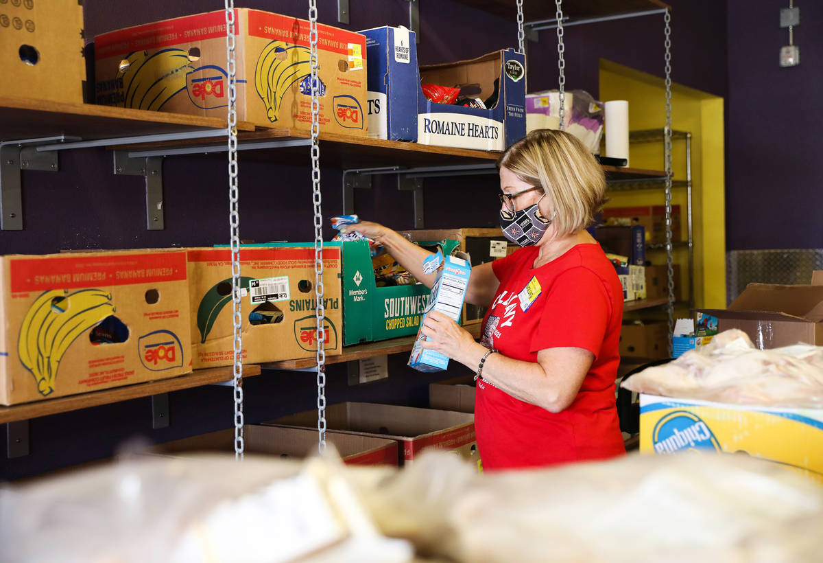 Volunteer Linda O’Connell packs boxes of food for people to pick up in the food pantry at Cat ...
