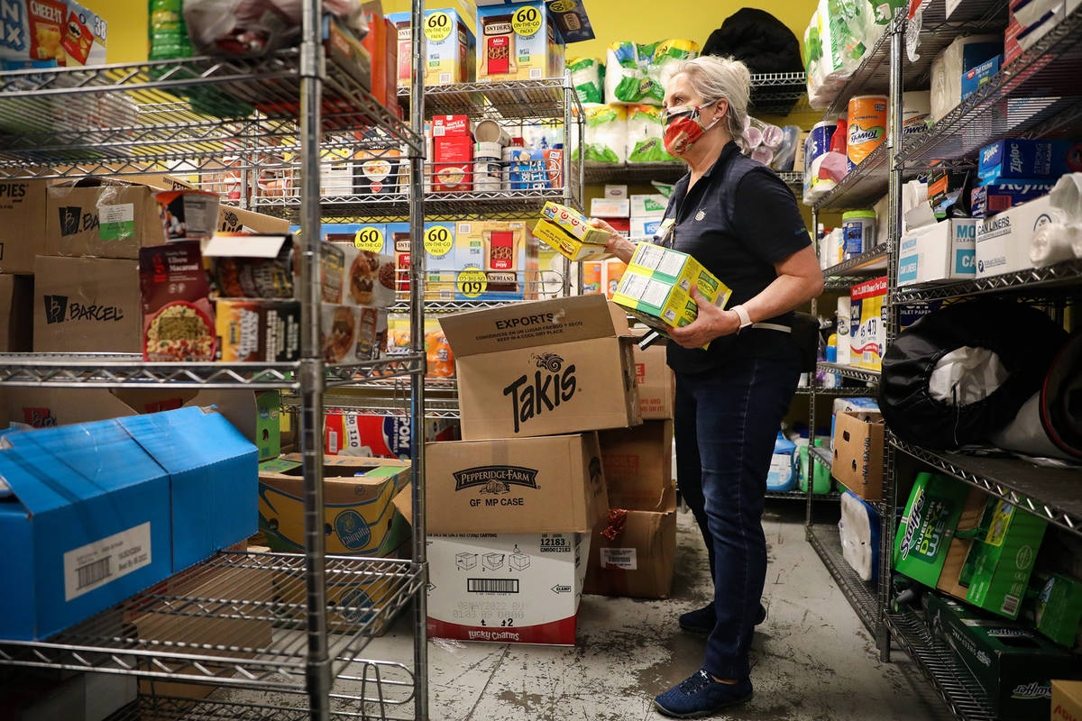 Volunteer Alicia Brasuell unloads items onto shelves in the storage room in the food pantry at ...