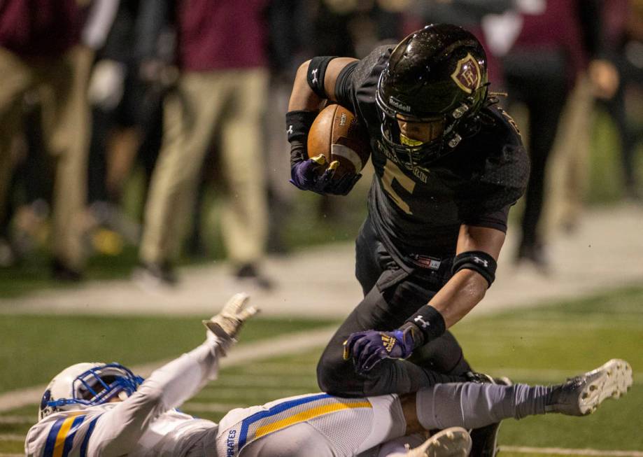 Faith Lutheran's Jordan Pollard (5) goes over the top of Moapa Valley's Chris Hoy (7) during th ...