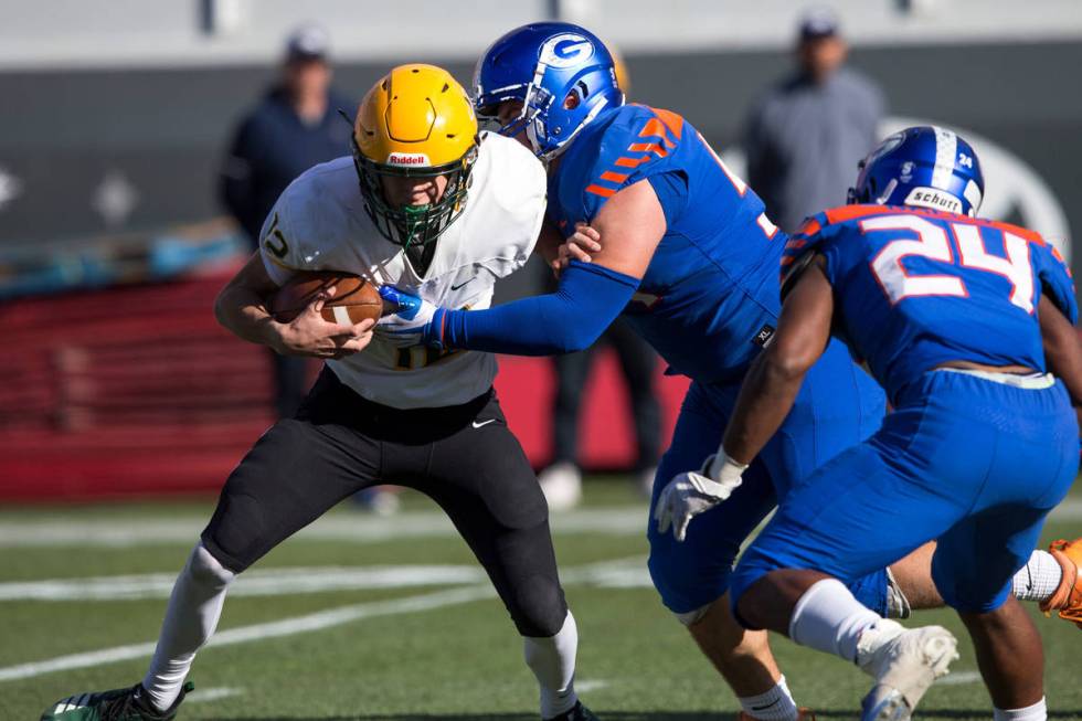 Bishop Manogue quarterback Drew Scolari (12) gets sacked by Bishop Gorman center Daniel Cooke ( ...