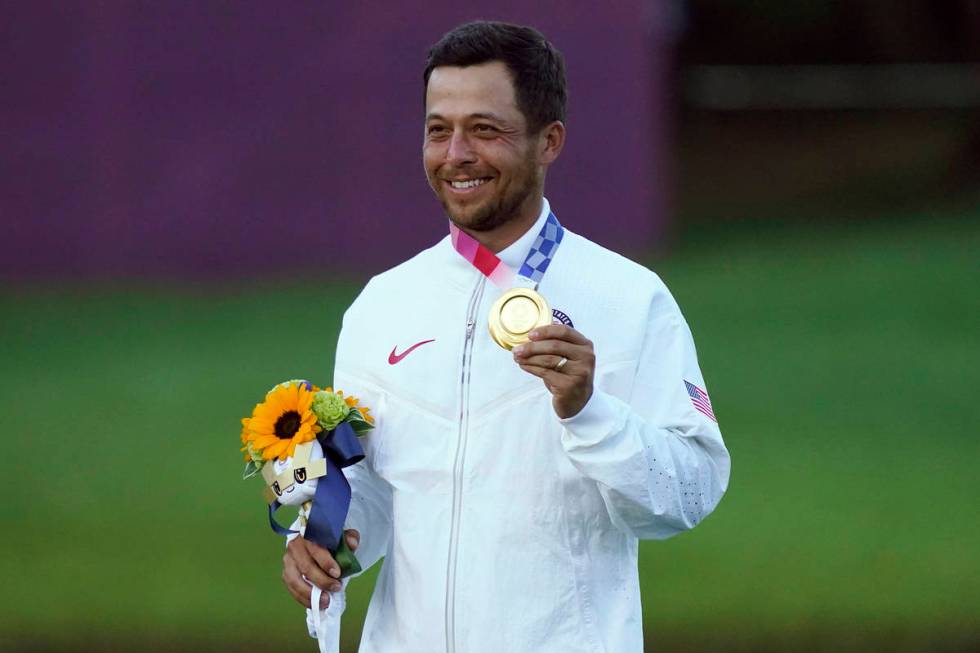 Xander Schauffele, of the United States, holds his gold medal after winning the men's golf even ...