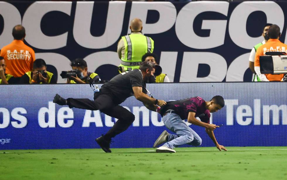 A security guard chases down a soccer fan during the second half of the Concacaf Gold Cup final ...