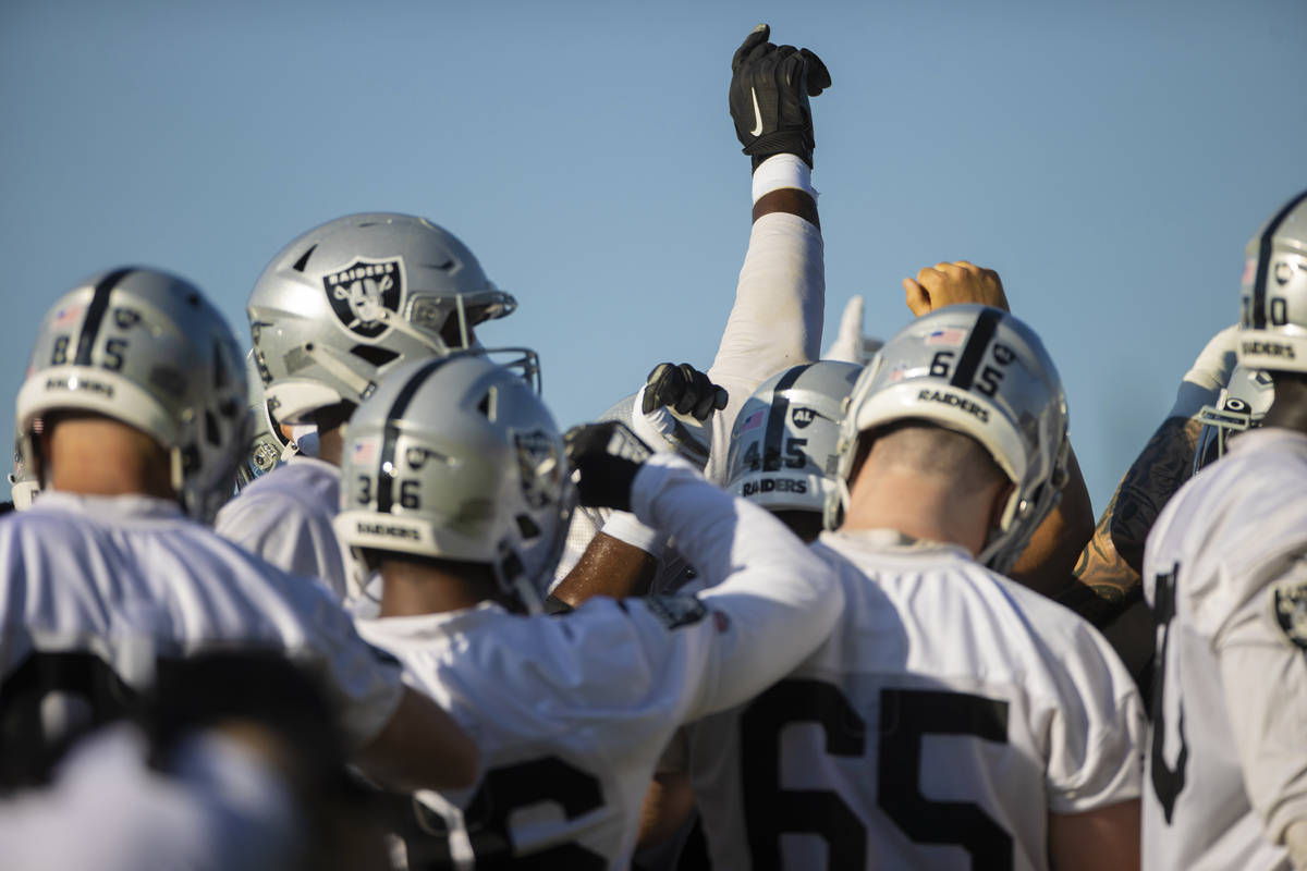 Raiders offensive players huddle before the start of training camp on Monday, Aug. 2, 2021, at ...