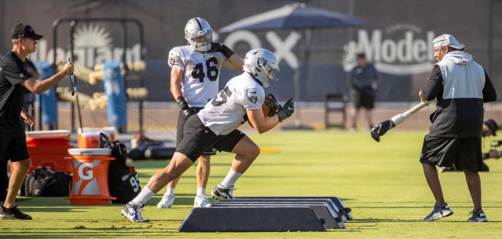 Raiders fullback Alec Ingold (45) is tethered by a wire on a run drill during practice at the I ...