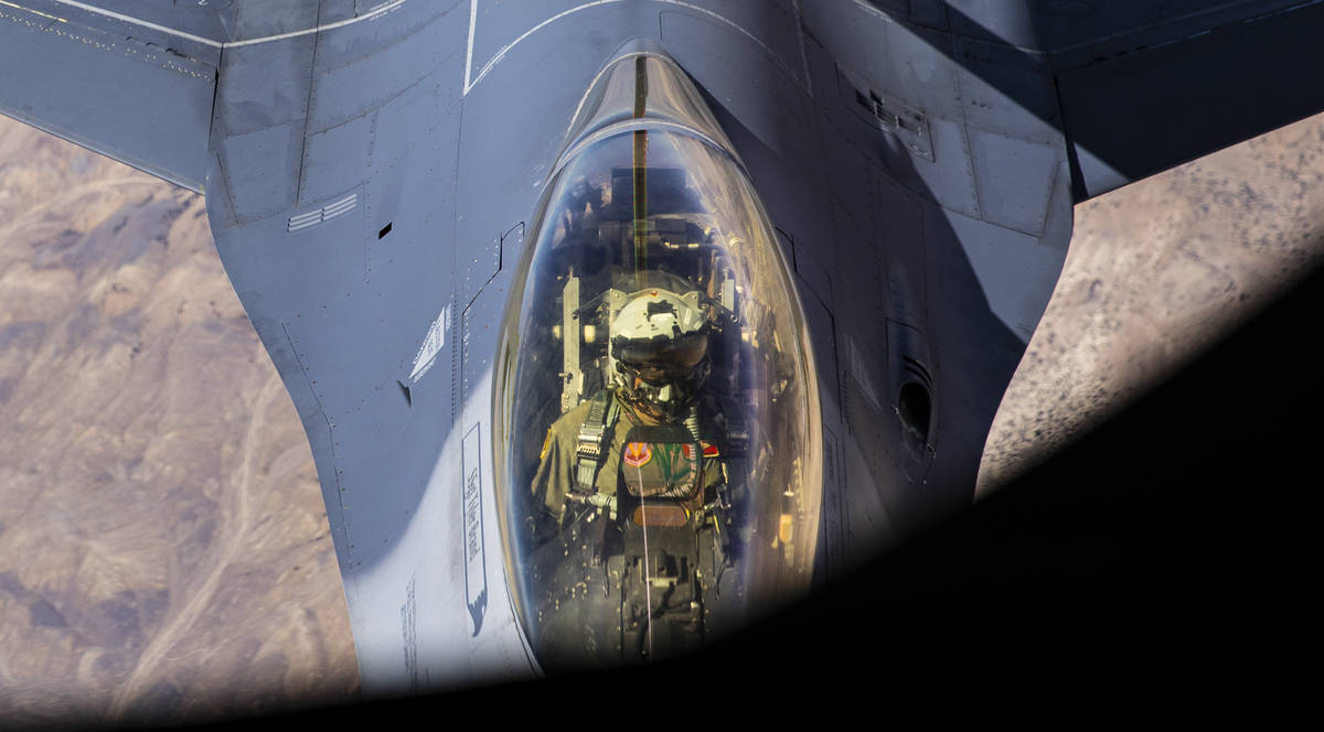 An F-16 pilot is seen while being refueled in-flight from a KC-135 Stratotanker flying around t ...