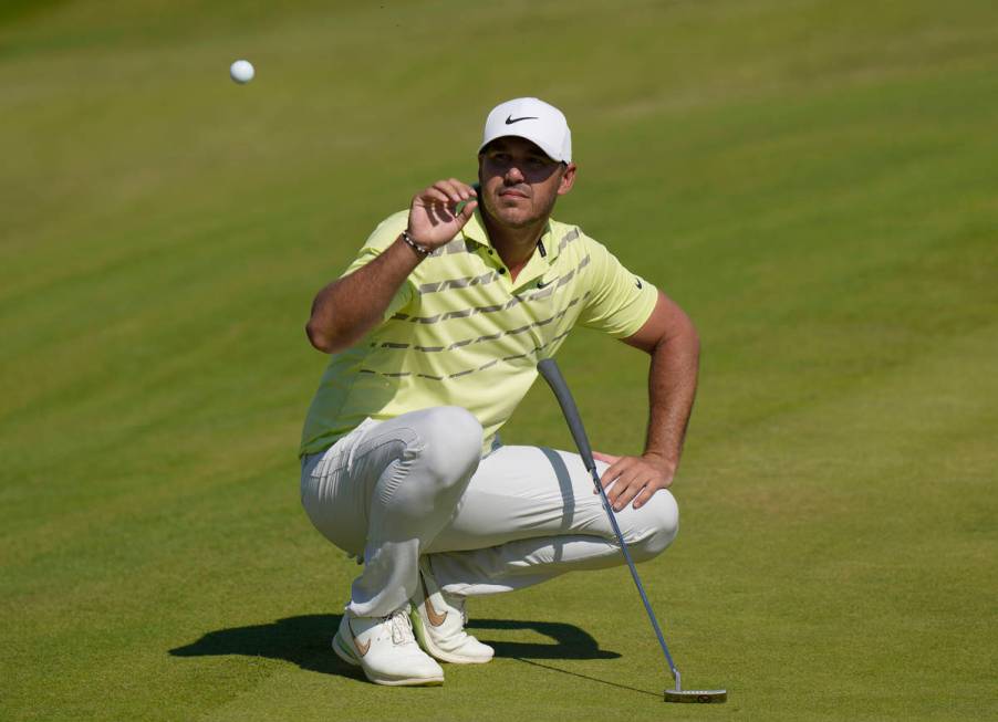 United States' Brooks Koepka catches his ball after it was cleaned by his caddie on the 18th gr ...