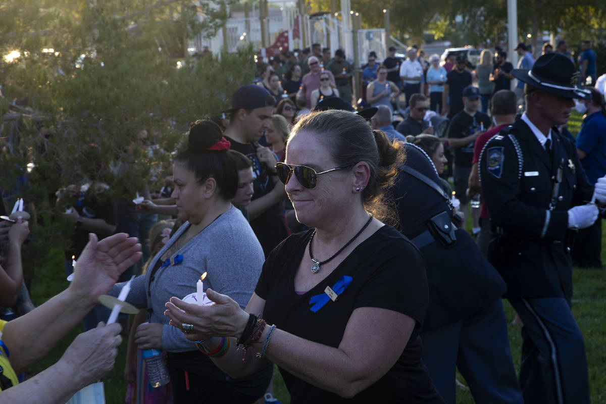 Lauren Hamilton, whose wife is a member of the Nevada Highway Patrol, helps to light candles du ...