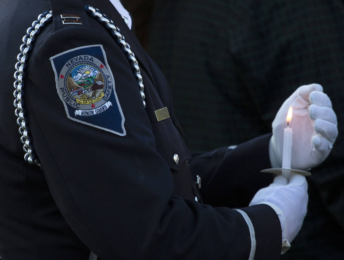 A member of the Honor Guard shields his candle during a vigil for Nevada Highway Patrol trooper ...