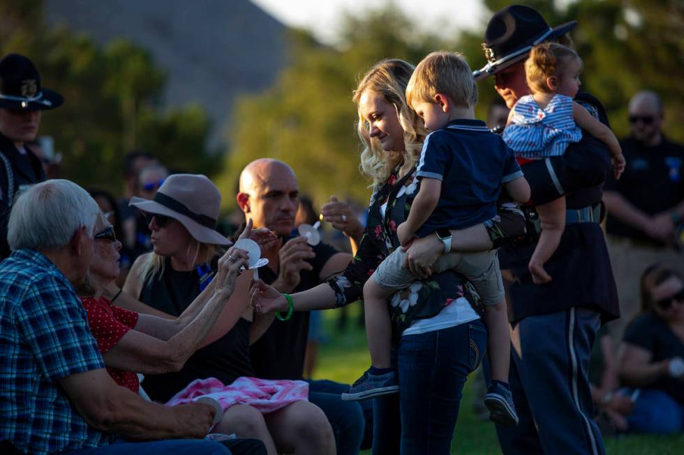 Joanna May, holding her son Raylan May, helps family members to light candles during a vigil fo ...