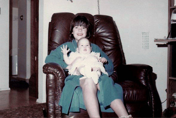 This Isaacson family picture from late 1983 to early 1984 shows Stephanie holding her baby sist ...