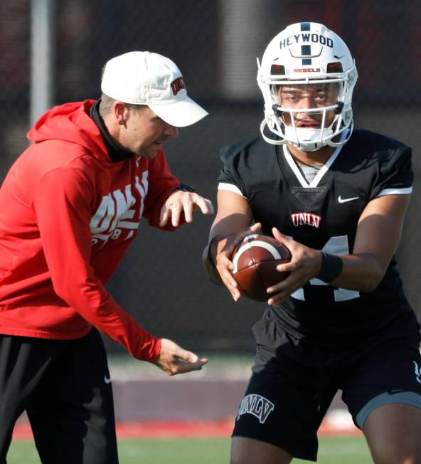 Glenn Thomas, offensive coordinator and quarterbacks coach, left, speaks to UNLV Rebels quarter ...