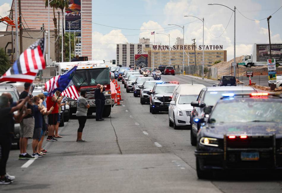Bystanders watch a procession moving the body of slain Nevada Highway Patrol Trooper Micah May ...
