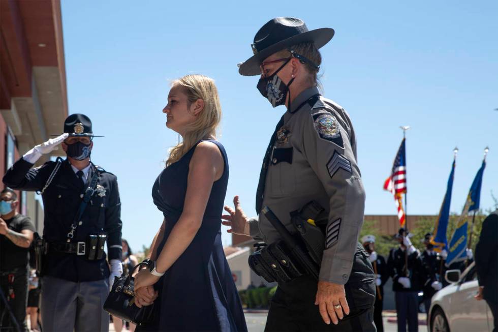 Joanna May, wife of Nevada Highway Patrol trooper Micah May, is guided into her husband's memor ...