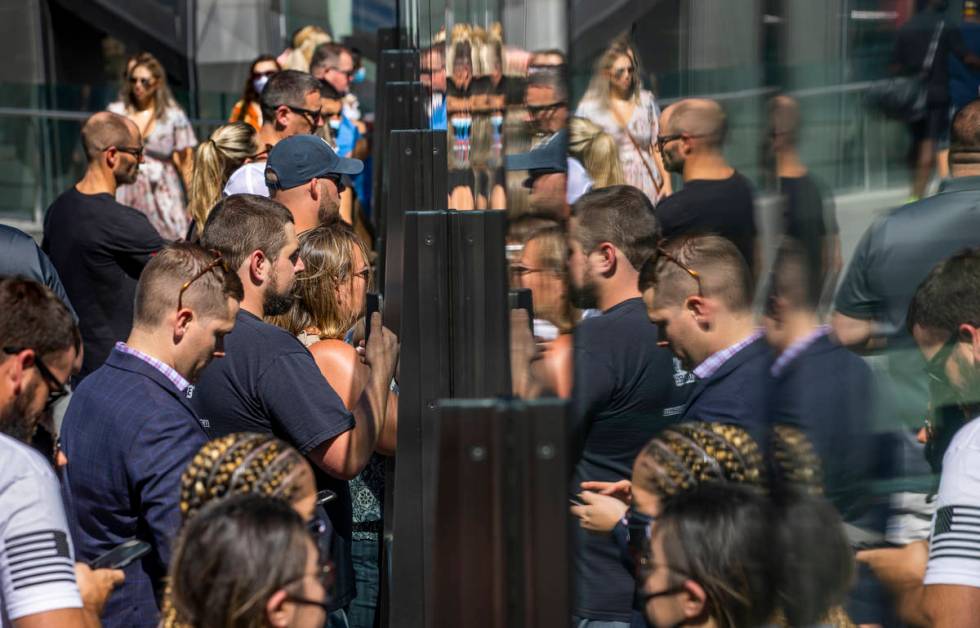 Bystanders on a pedestrian bridge near the Cosmopolitan watch the processional for Nevada Highw ...