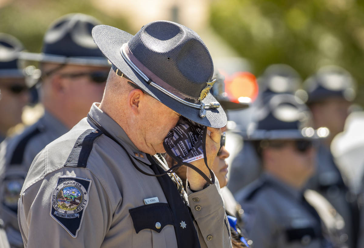 Capt. K. Honea wipes a tear during a graveside service at Palm Eastern Mortuary and Cemetery on ...