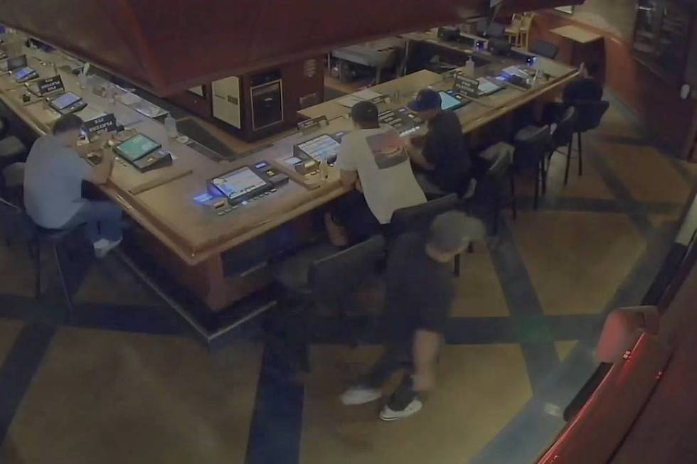 A man carries a gun inside a PT's in central Las Vegas in June. (screenshot/surveillance video)