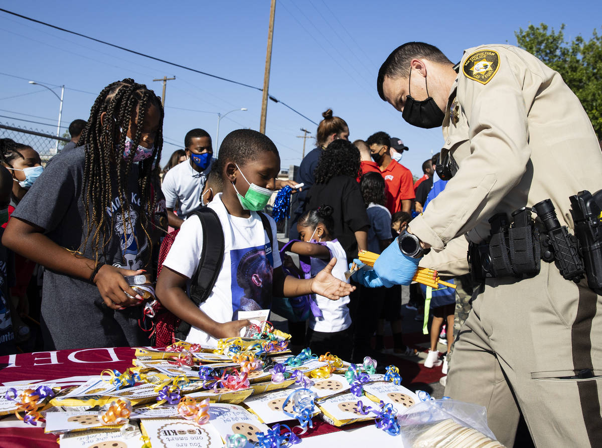 The Las Vegas Metropolitan police officer B. Hatfield hands out school supplies for Kelly Eleme ...