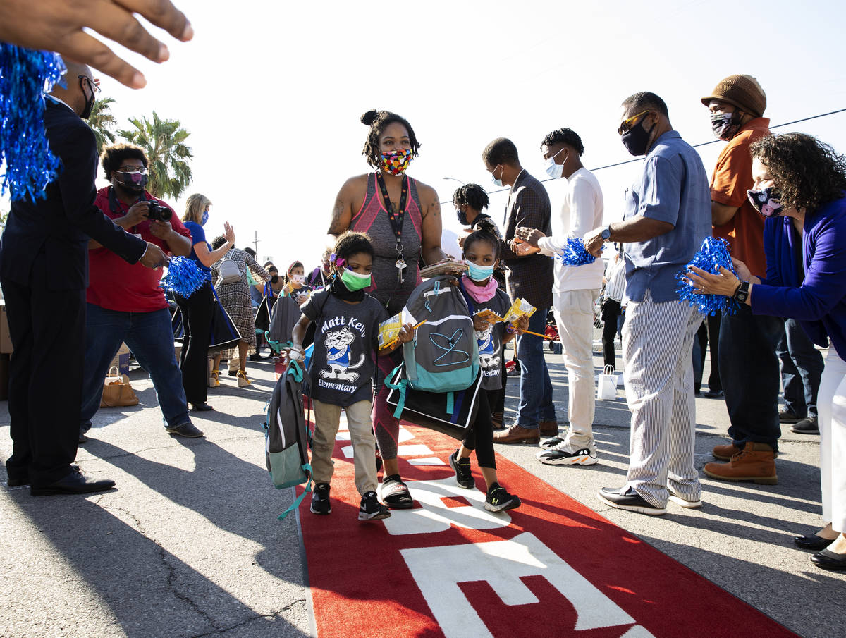 Briana Walker and her children Briarie, 5, left, and Brielle, 6, walk the red carpet as communi ...