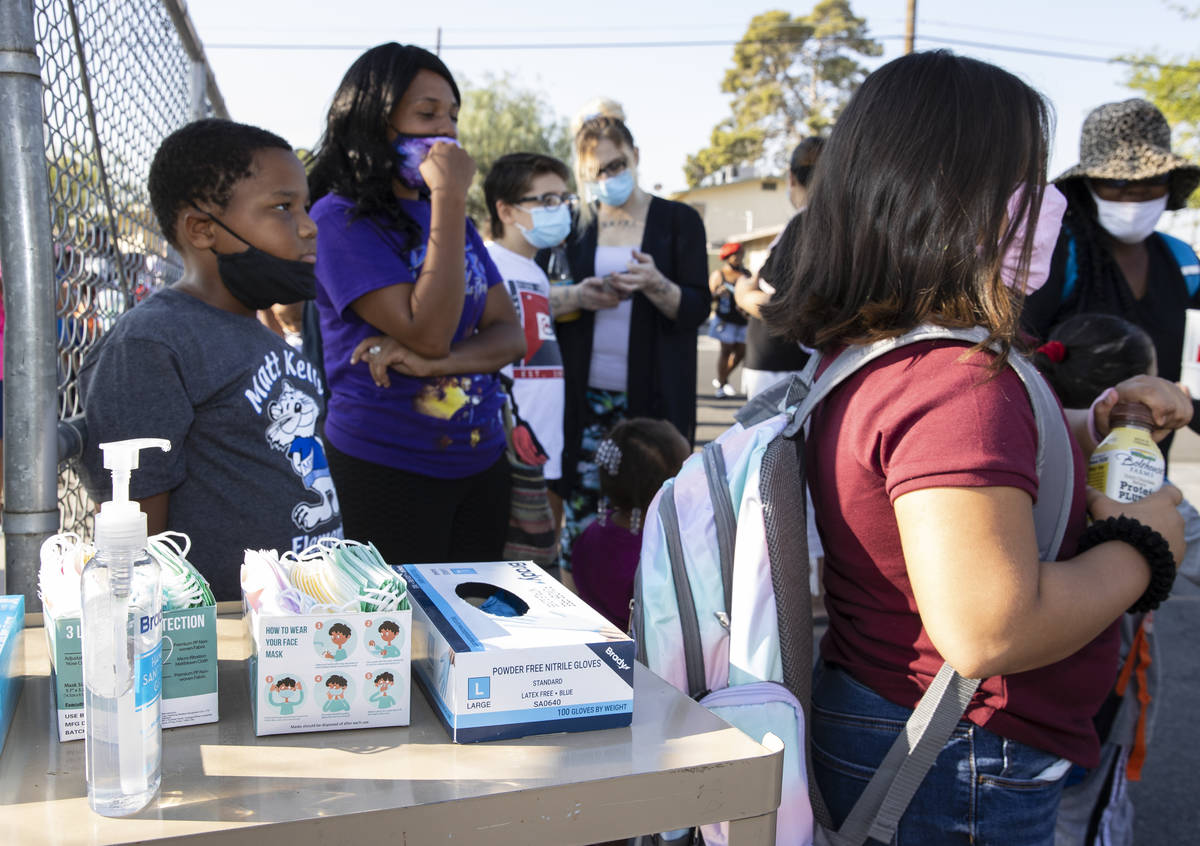 Hand sanitizer and face masks are displayed outside of Kelly Elementary Community School as stu ...