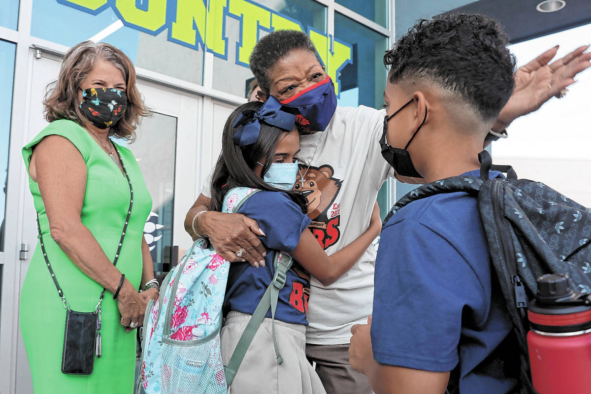 School namesake Hannah Marie Brown hugs Carmyn Reyes, 10, and Dante Haylock, 9, during a ribbon ...