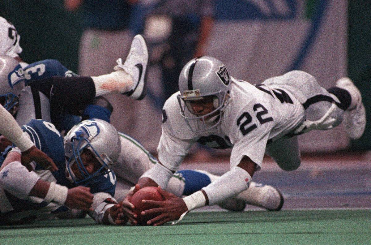 Cornerback Mike Haynes (22) of the Los Angeles Raiders dives to grab the football fumbled by Cu ...