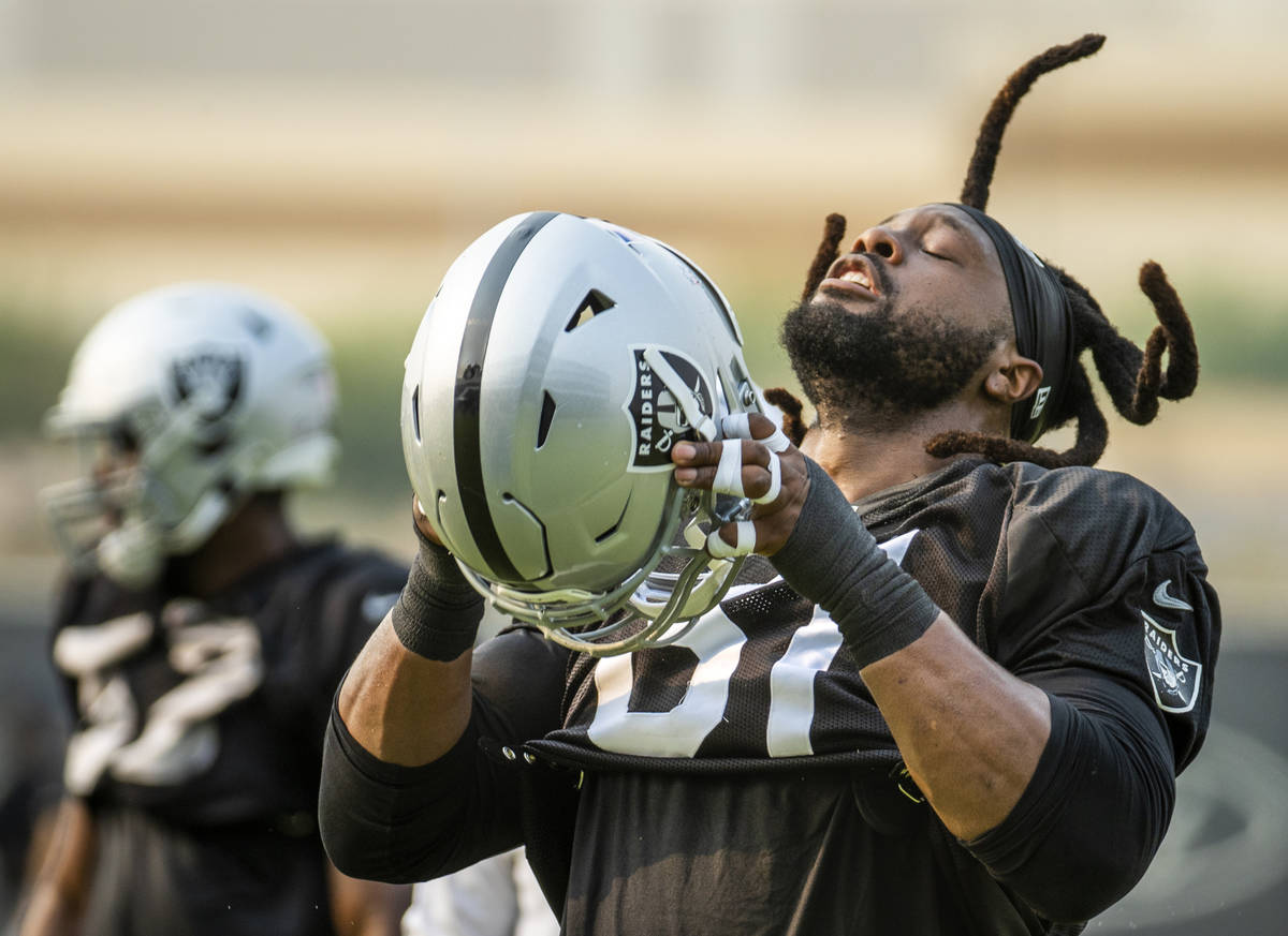 Raiders defensive tackle Gerald McCoy (61) throws his hair back to put his helmet on during pra ...