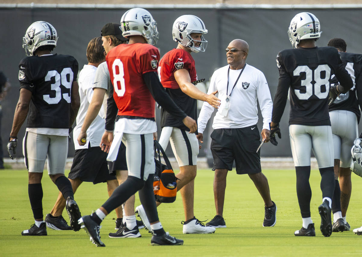 Raiders defensive backs coach Ron Milus, center, looks on as quarterbacks arrive to drill durin ...