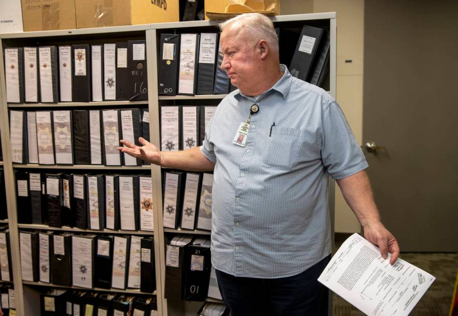 Metropolitan Police Department cold case detective Kenneth Hefner stands in front of the many b ...