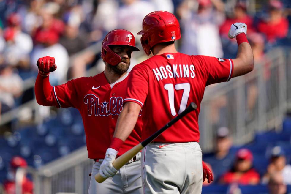 Philadelphia Phillies' Bryce Harper, left, celebrates with teammate Rhys Hoskins after hitting ...
